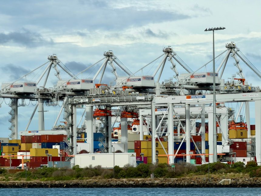 Terminal portuário automatizado com guindastes e contêineres organizados.