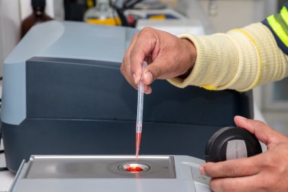 Técnico de laboratório utiliza uma micropipeta para realizar medições precisas em um ambiente de pesquisa.