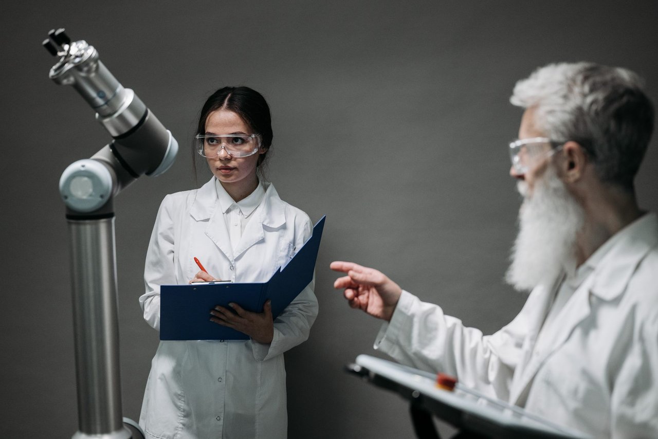 Pesquisadores de jaleco analisam equipamentos robóticos em um laboratório de tecnologia médica.