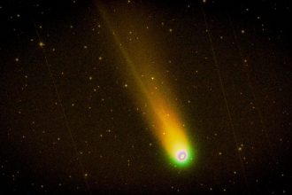 Cometa brilhante com cauda luminosa atravessando um céu noturno estrelado
