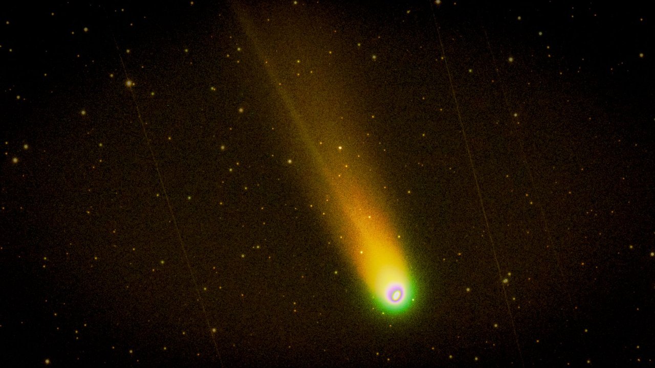 Cometa brilhante com cauda luminosa atravessando um céu noturno estrelado